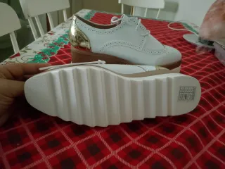 Zapatos blancos con detalle dorado