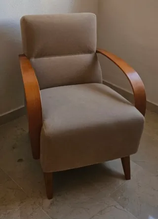 Sillón tapizado beige con brazos de madera