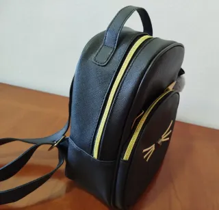 Mochila gato negra con detalles dorados