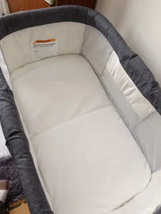 Cuna de viaje gris con mosquitera