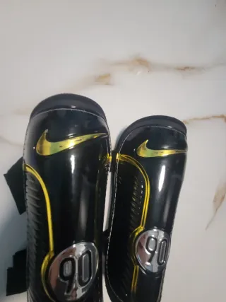 Espinilleras Nike 90 Negras Doradas