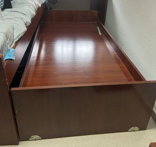 Cama nido de madera oscura con cajones