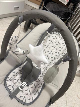 Mecedora de bebé gris con juguetes