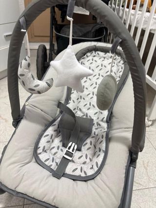 Mecedora de bebé gris con juguetes