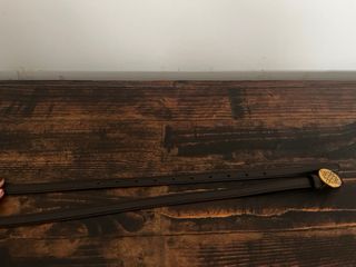 Cinturón fino marrón con hebilla dorada