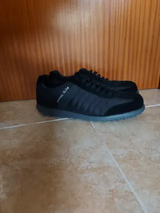 Chaqueta de traje gris y zapatillas Camper.