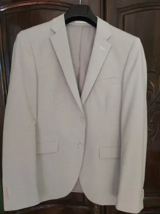 Chaqueta de traje gris y zapatillas Camper.