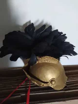 Casco dorado con plumas negras