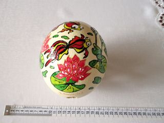 Uovo di struzzo decorato con pesci e fiori. Vuoto.