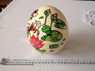 Uovo di struzzo decorato con pesci e fiori. Vuoto.