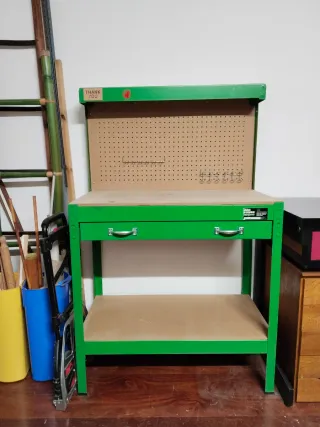Mesa de trabajo verde con panel perforado