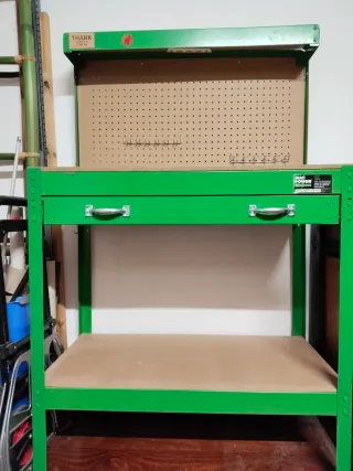 Mesa de trabajo verde con panel perforado