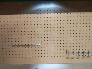 Mesa de trabajo verde con panel perforado