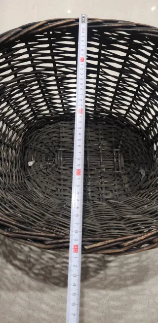 Cesto de mimbre marrón con asas.