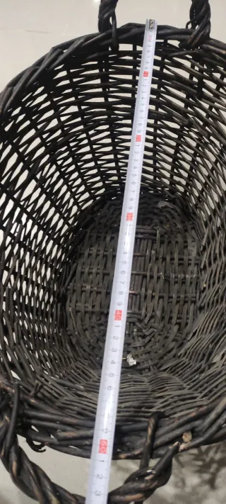 Cesto de mimbre marrón con asas.