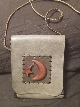 Bolso de bandolera con adorno de luna y estrella.