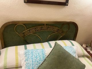 Cabecero de cama dorado y verde de latón.
