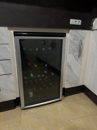 Vinoteca 28 botellas con golpe en marco inferior.