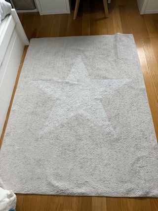 Alfombra gris con estrella blanca.