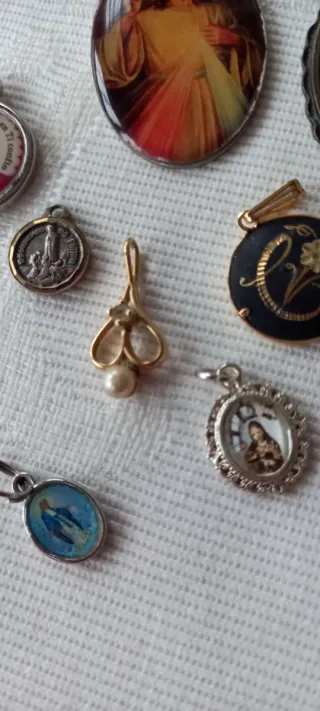 Lote religioso: 7 medallas y colgante dorado.