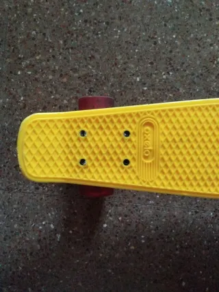 Mini skate amarillo con ruedas rojas
