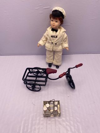 Bambola porcellana con bicicletta e latte
