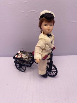 Bambola porcellana con bicicletta e latte