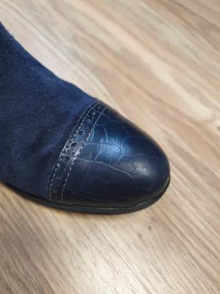 Botas altas ante azul marino