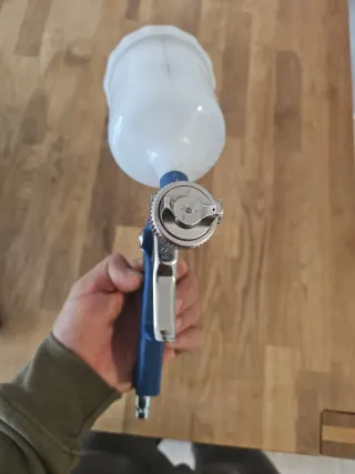 Pistola de pintura azul con depósito