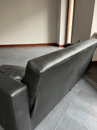 Divano nero in similpelle con cuscini