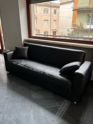 Divano nero in similpelle con cuscini
