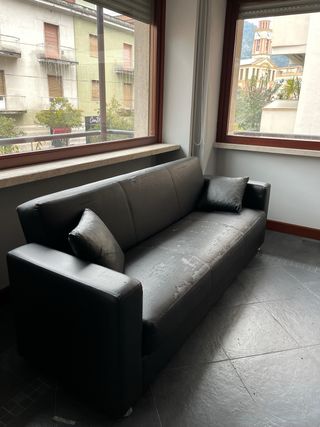 Divano nero in similpelle con cuscini