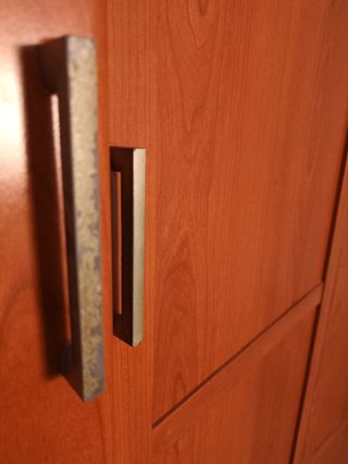 Armario con espejos y cama con cabecero.