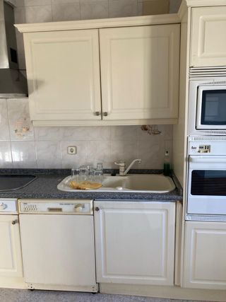 Cocina completa beige y blanca.