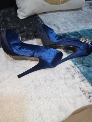Zapatos de tacón azul con lazo plateado