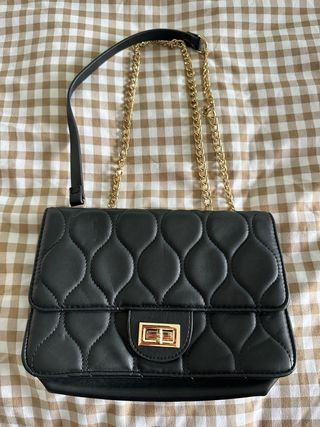 Bolso negro acolchado con cadena dorada