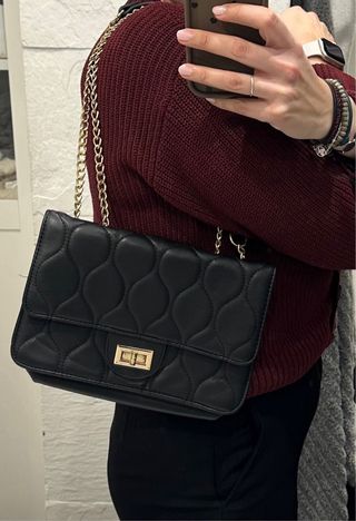 Bolso negro acolchado con cadena dorada