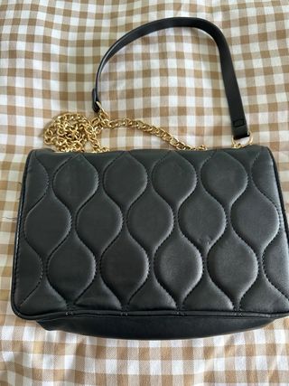 Bolso negro acolchado con cadena dorada