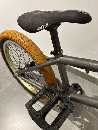 Bici BMX gris con ruedas naranjas