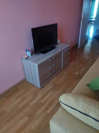 Sofá cama amarillo con cojines y muebles.