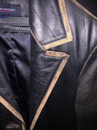 Chaqueta de piel negra con ribetes dorados