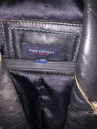 Chaqueta de piel negra con ribetes dorados