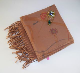 Sciarpa marrone con frange e spilla floreale