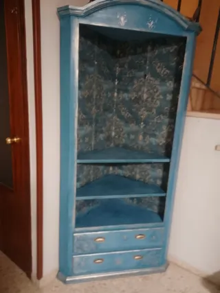Mueble esquinero azul y oro con decoracion de reli