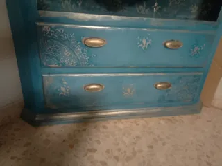 Mueble esquinero azul y oro con decoracion de reli