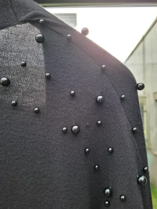 Chaqueta de punto negra con perlas
