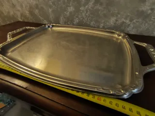 Vassoio da portata in metallo con manici decorati.