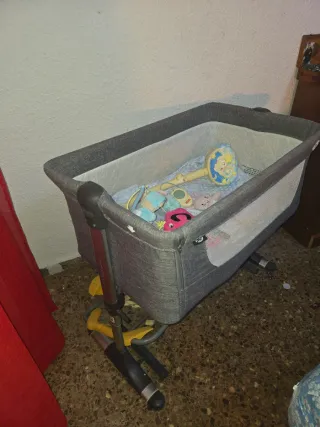 Minicuna gris con juguetes