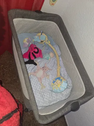 Minicuna gris con juguetes