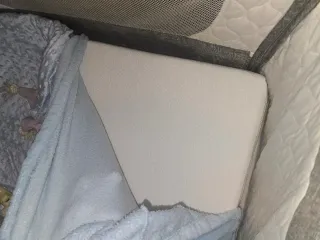 Minicuna gris con juguetes